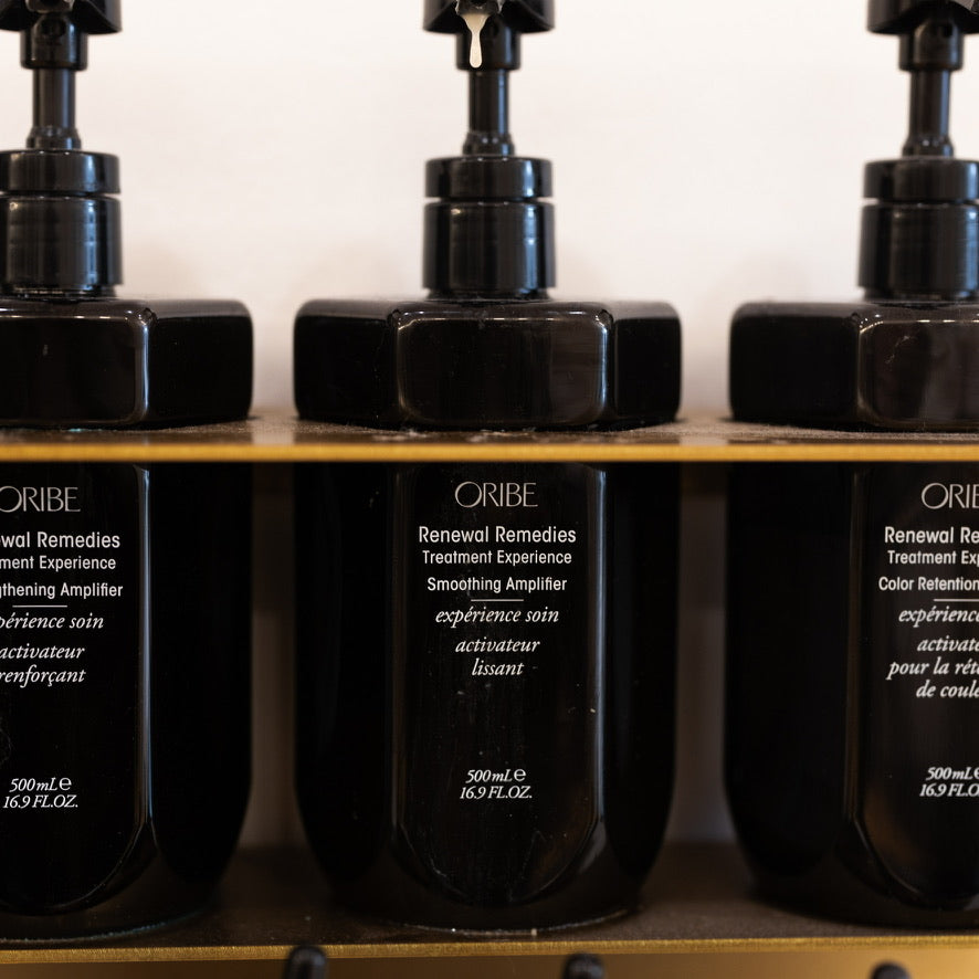 Oribe Renewal Remedies treatment bottles displayed on a salon shelf