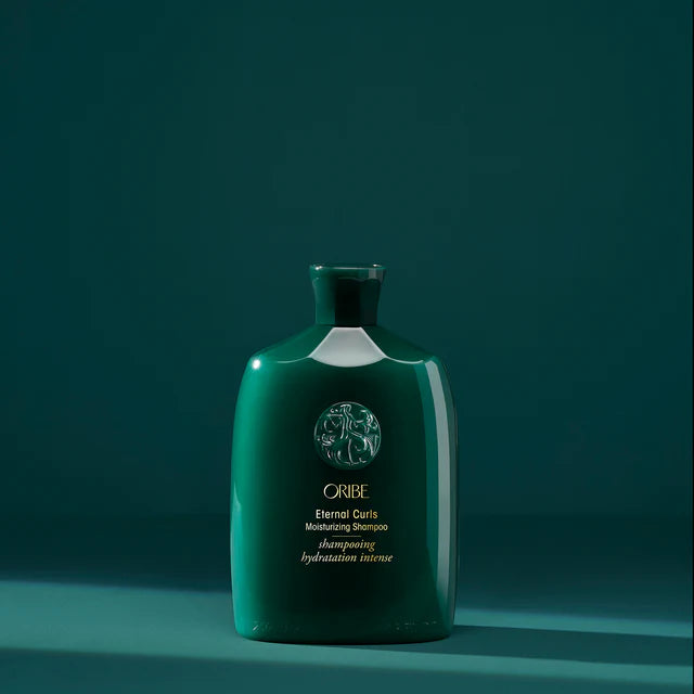 Oribe Eternal Curls Moisturizing Shampoo bottle on teal background, hydrating cleanse for curly hair.