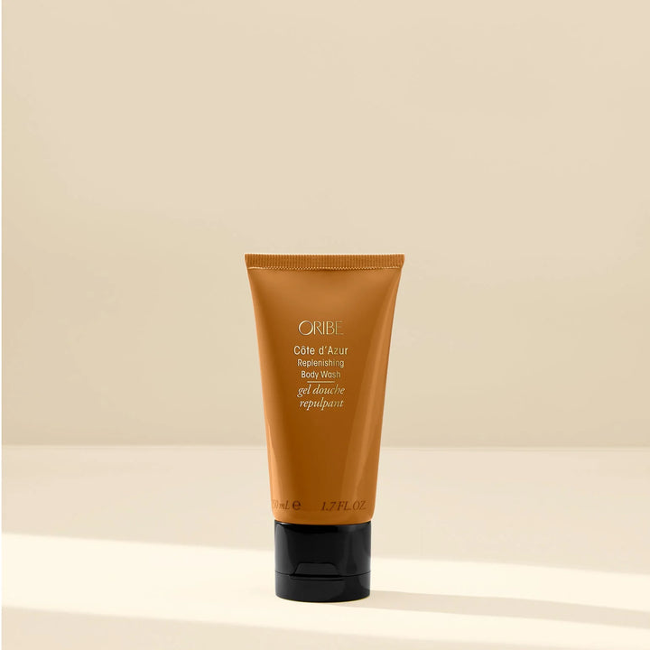 Oribe hair product tube on a beige background